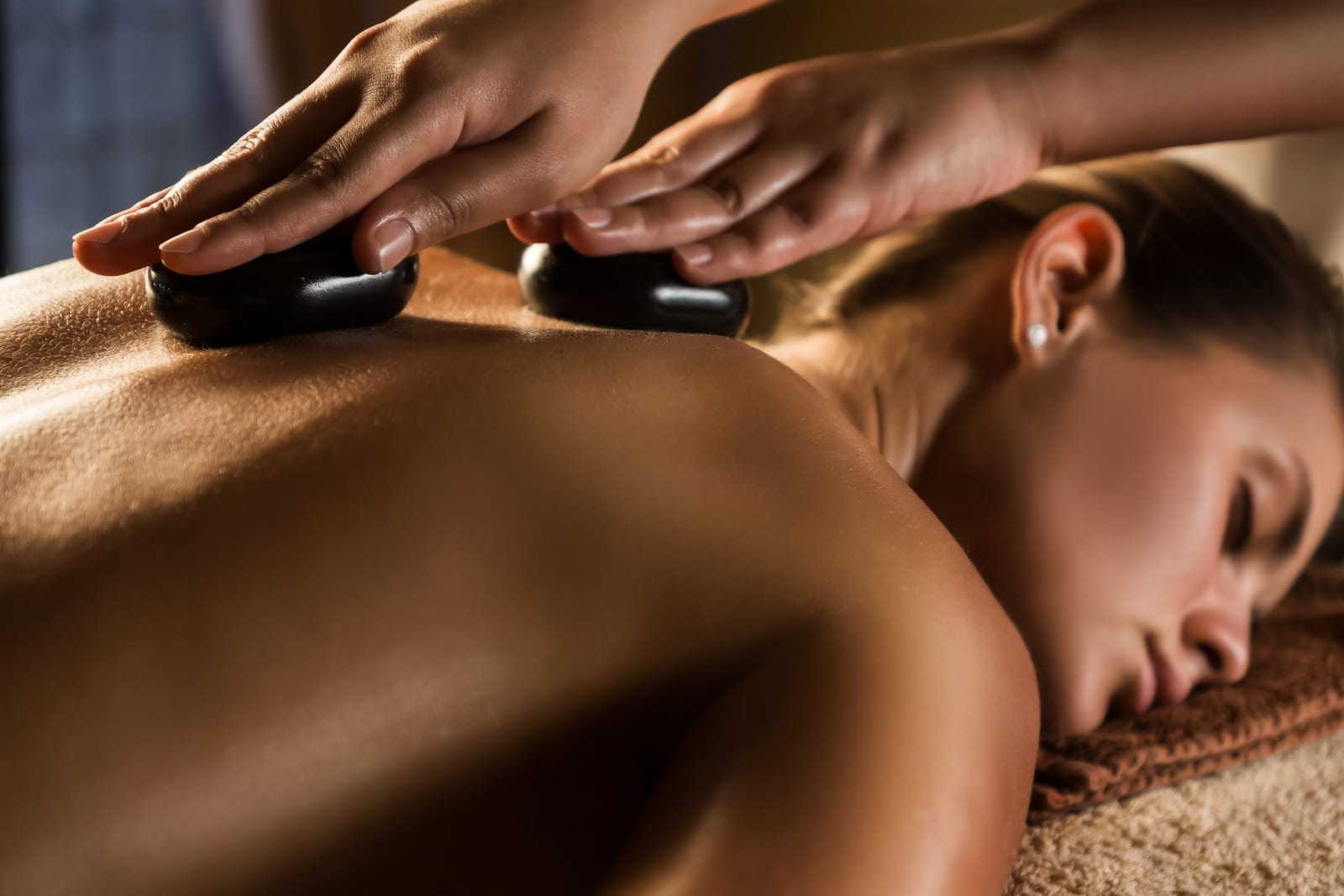 Hot stone massage with warm stones on the back